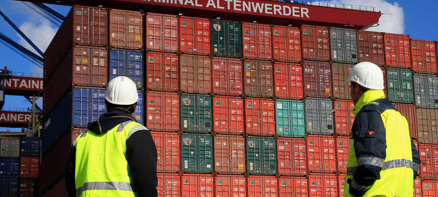 Employees watch the Container ship 'Hyundai Force' during loading at the Container Terminal Altenwerder (CTA) at Hamburg harbour 