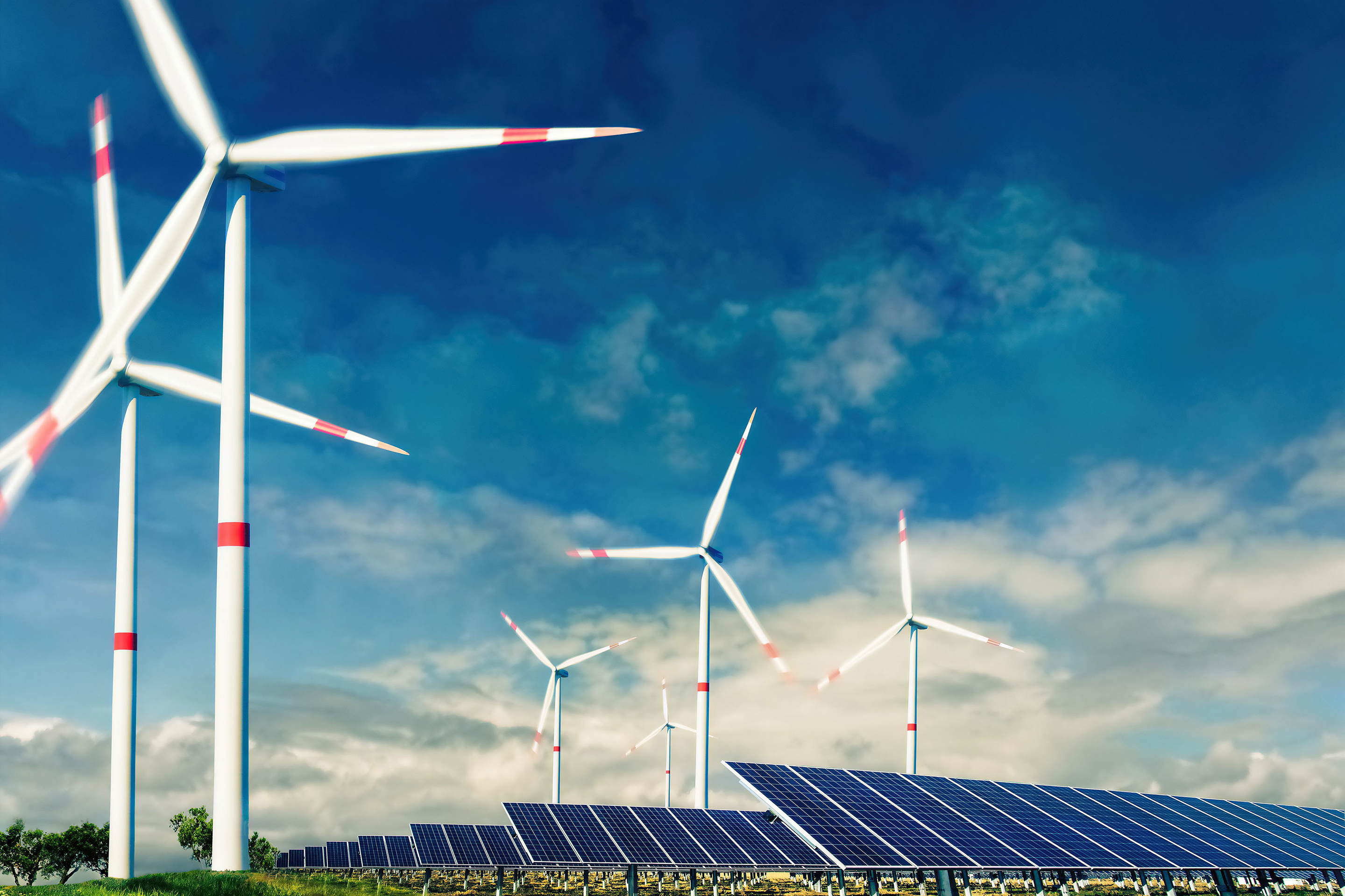 Photovoltaikanlage und Windkraftanlage vor blauem Himmel 