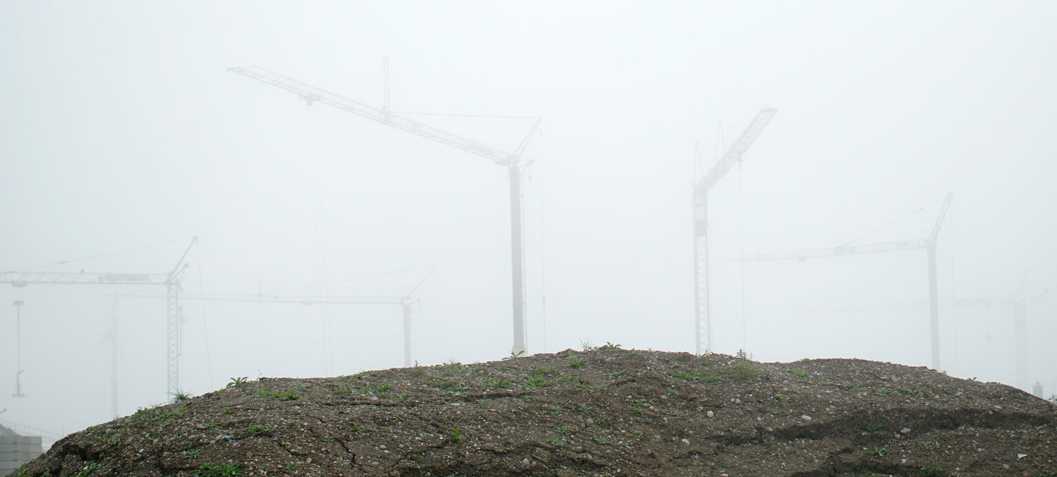 Baustelle fuer eine Wohnanlage in einem Wohngebiet im Morgennebel