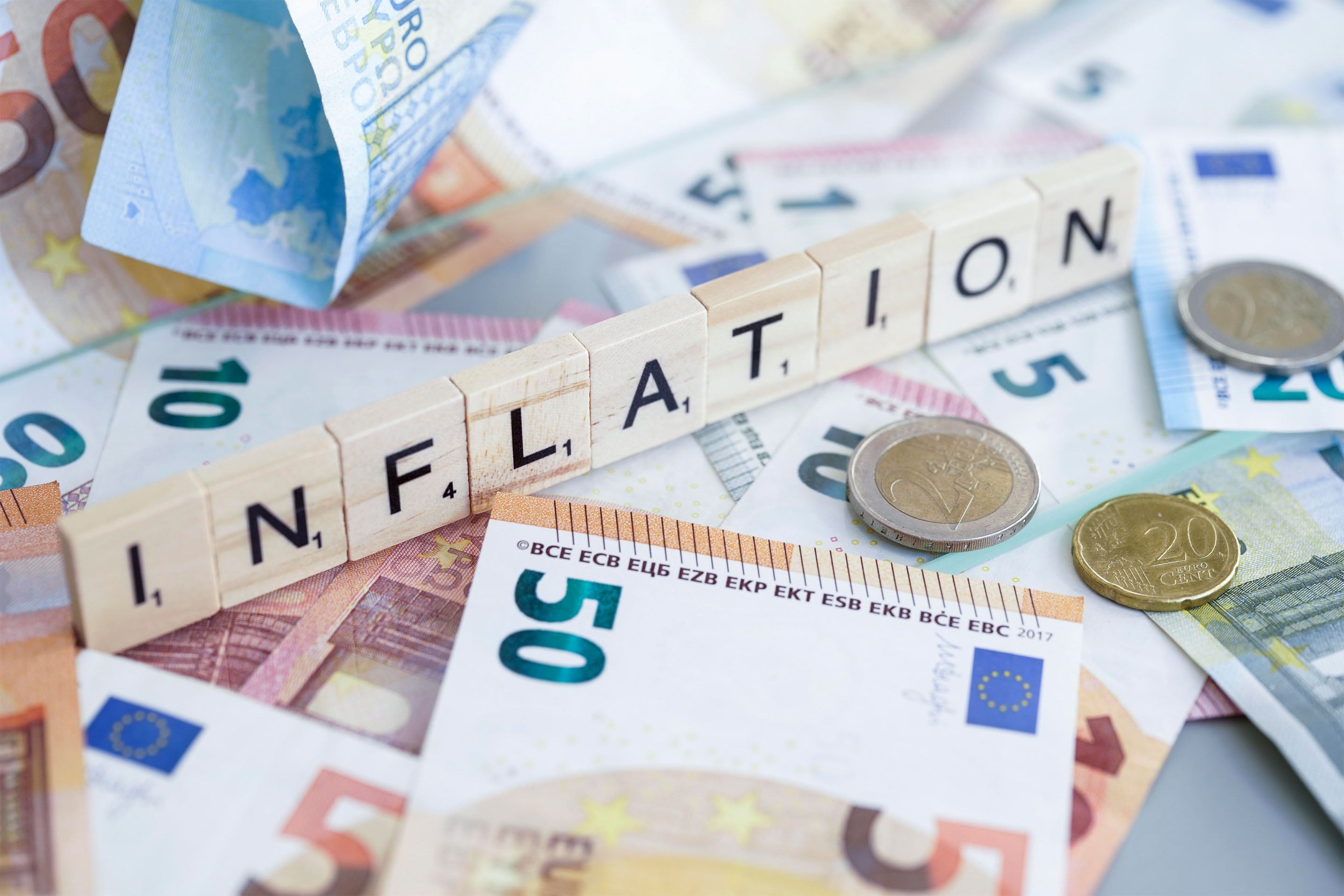Symbolfoto Inflation Inflationsrate mit Geldscheinen und Geldmuentzen im Hintergrund 
