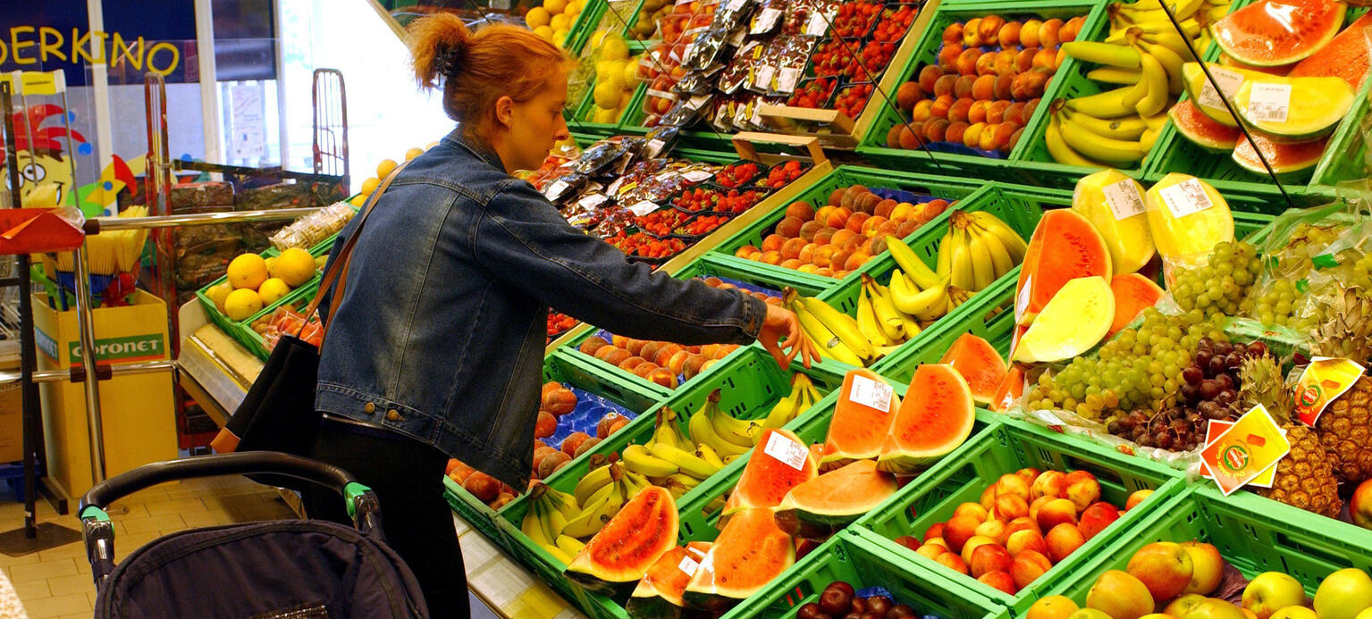 Berlin: Einkauf in einem Supermarkt - eine junge Frau mit einem Kinderwagen sucht an der Obsttheke in einem Spar-Markt in Berlin-Treptow Bananen aus, PM NWI 2023