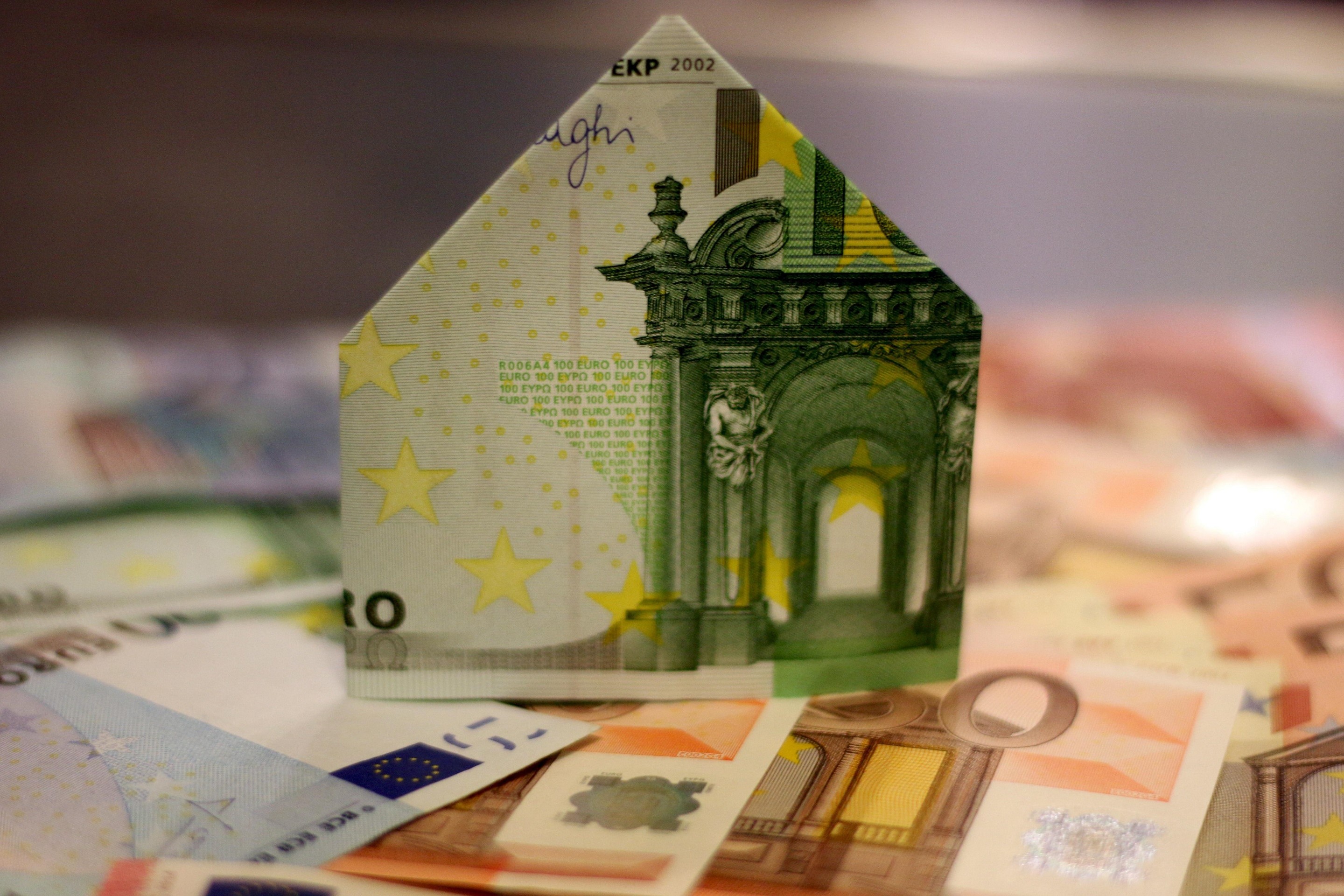 Haus aus 100 Euro Schein steht auf anderne Euronoten